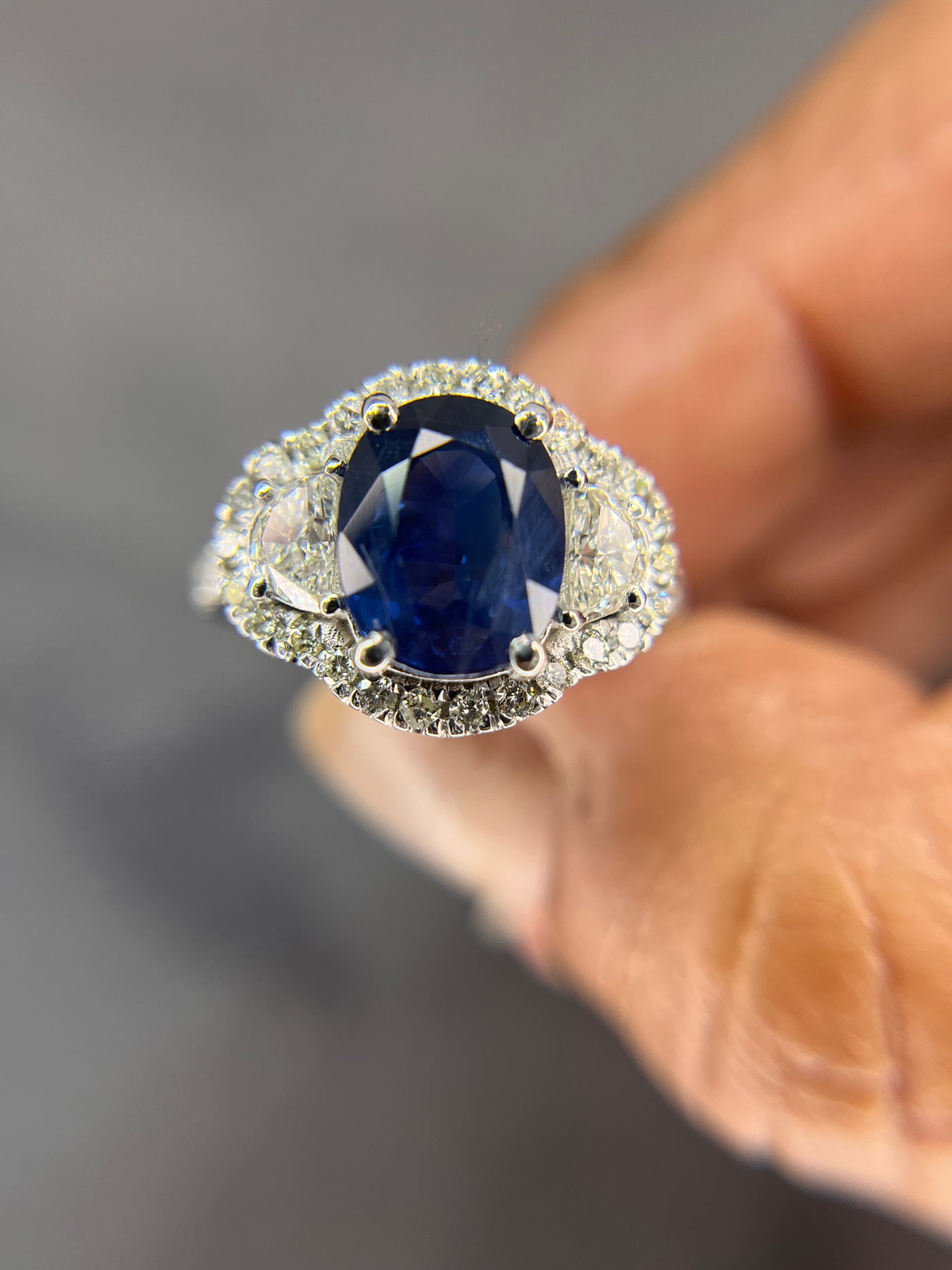 Halo Design 2 Ct. Tw. Oval Cut Natural Blue Sapphire with 1.25 Ct. Tw. Half Moon and Round Cut Side Diamond Ring